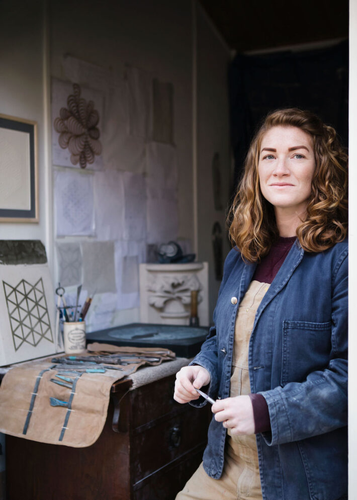 Stonecarver-Zoe-Wilson-phootgraphed-in-her-studio-with-her-bench-and-tools-in-the-background